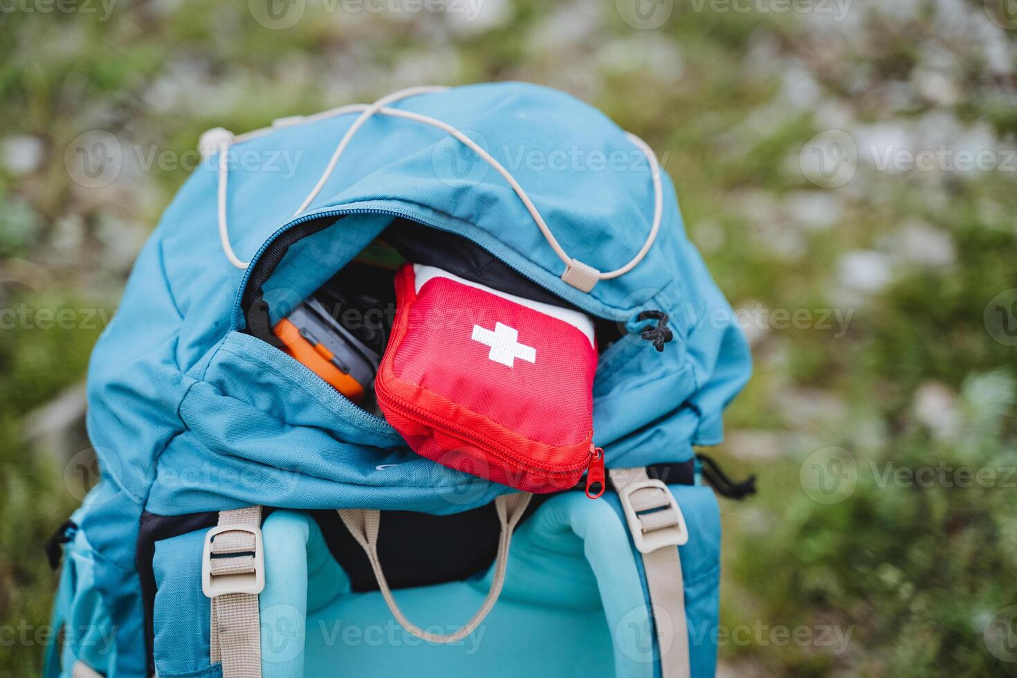 primero ayuda equipo para viaje es en el bolsillo de el mochila, emergencia asistencia en caso de lesión en el viaje un conjunto de medicamentos en un rojo bolsa, el concepto de un primeros auxilios equipo médico foto