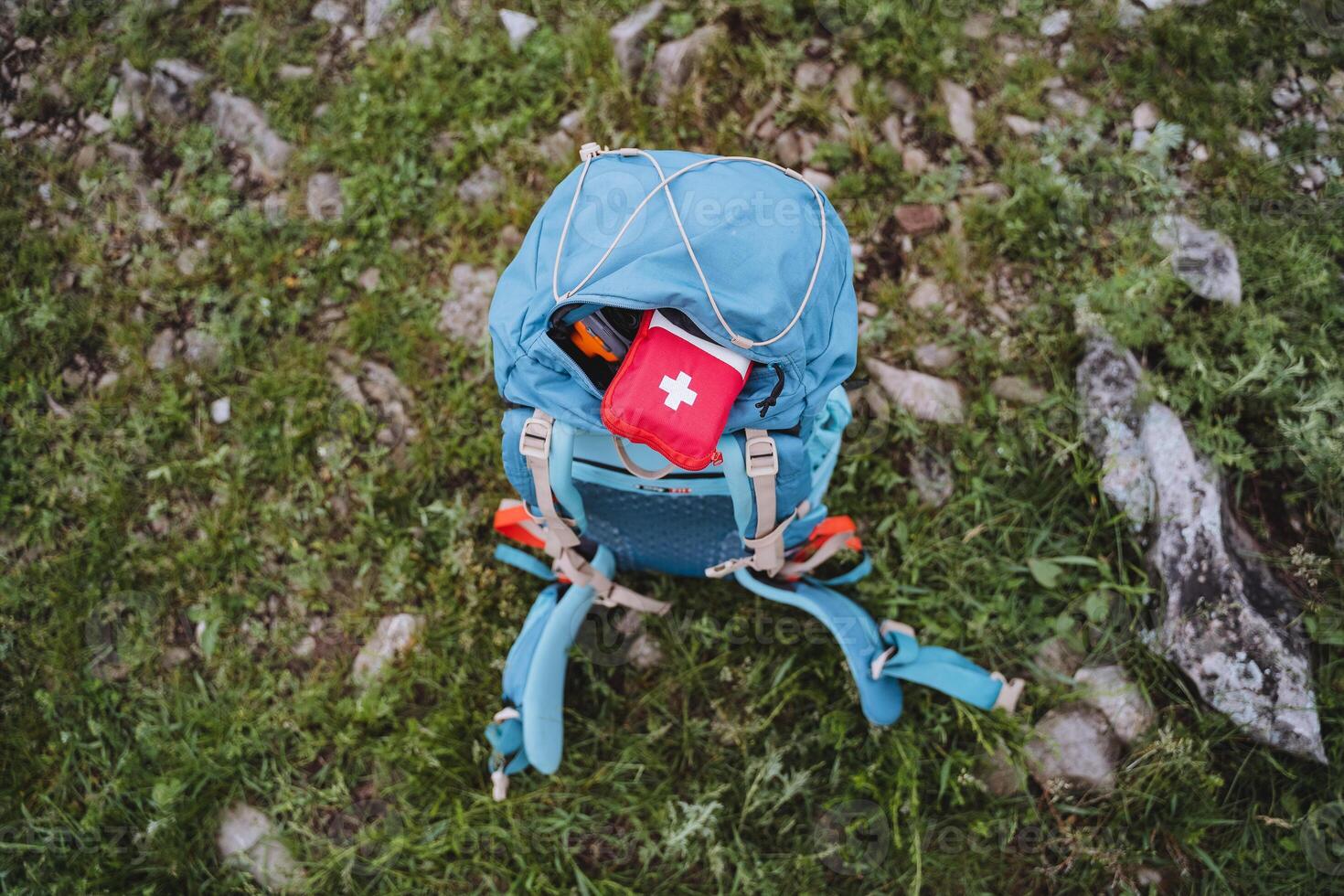 turista equipo poner un primeros auxilios equipo en un mochila, un rojo primero ayuda equipo es en el bolsillo de el bolsa, equipo para excursionismo en el montañas, trekking solo. foto