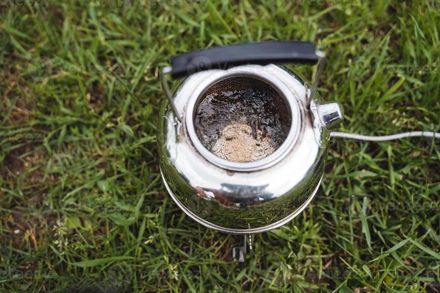 A tourist kettle boils on a gas burner, boiling water view from above, drinking utensils, brewing tea. photo