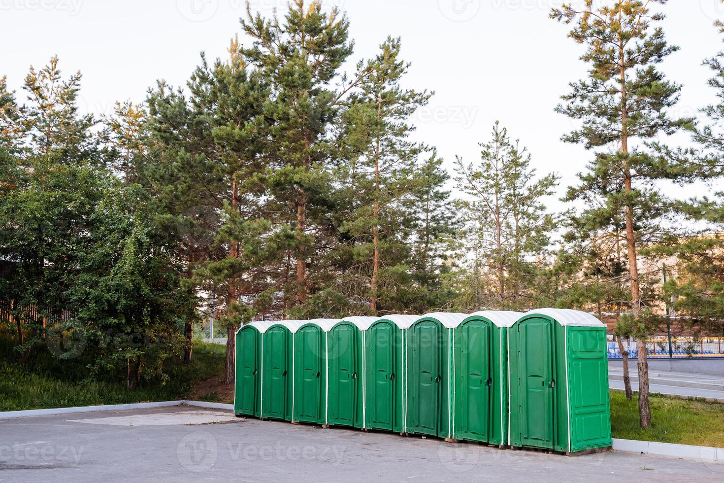 Outdoor cabins of the composting toilet stand in one row on the square in the city park, a plastic box for the toilet. photo