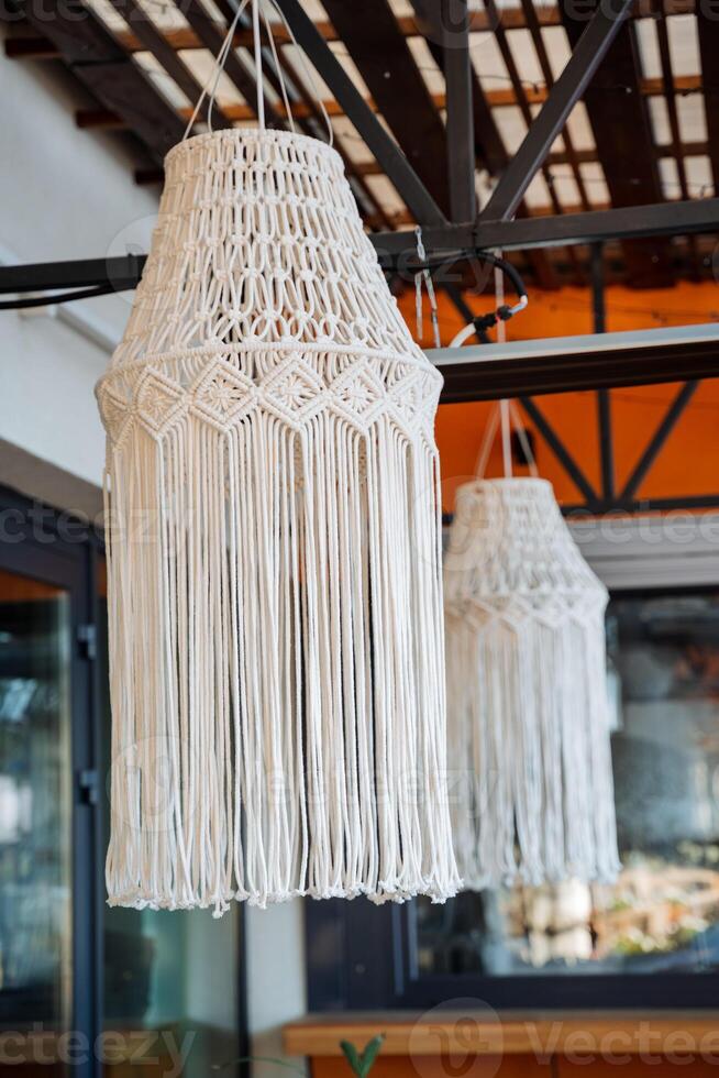 diseñador candelabro en el cafetería, boho estilo en el interior de el casa, calle restaurante, hecho a mano, mimbre cable cuerda colgando en el techo. foto