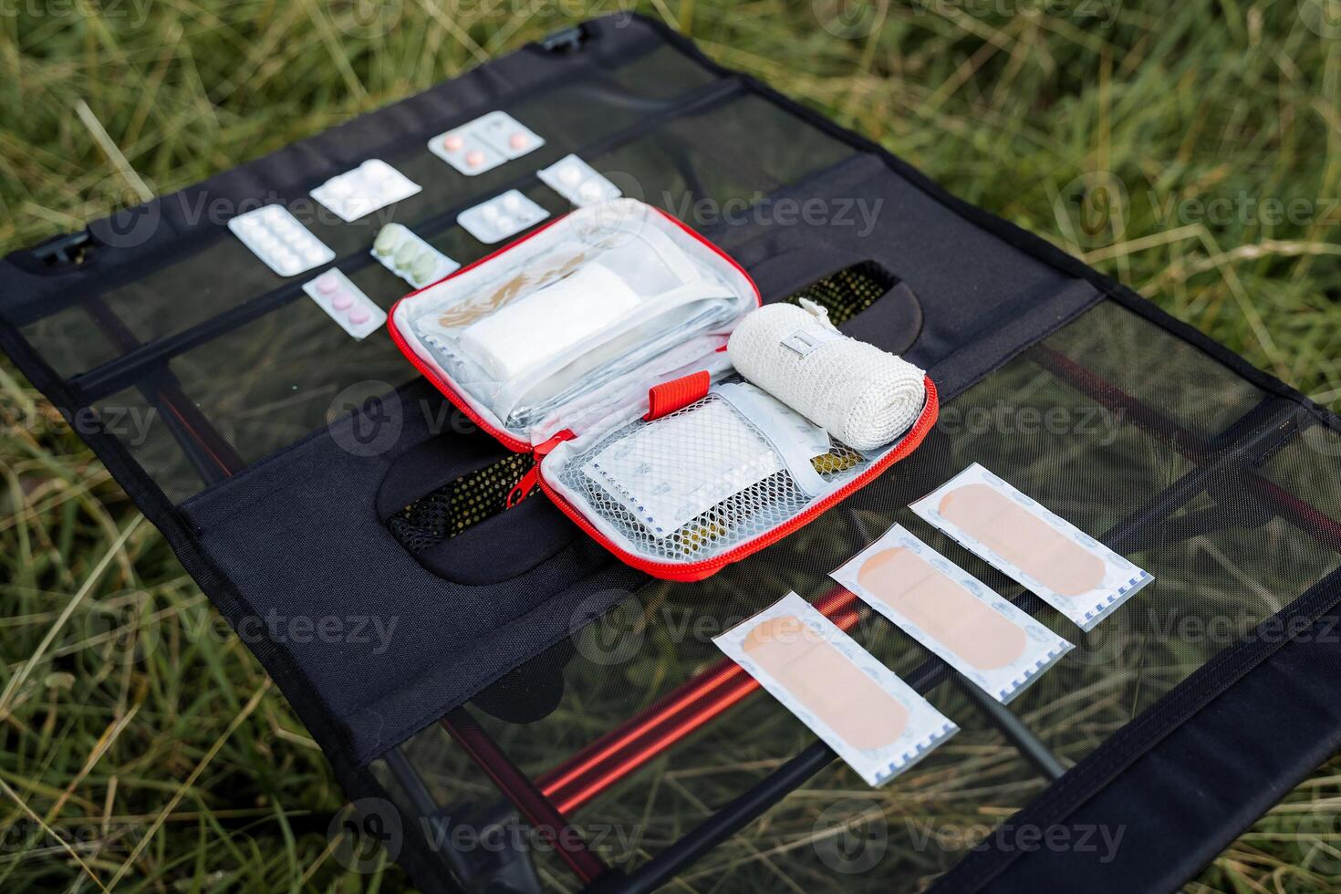 On the table is a first-aid kit in an unfolded form, a set of medicines for a trip to nature. First aid kit, medicines on the road. photo