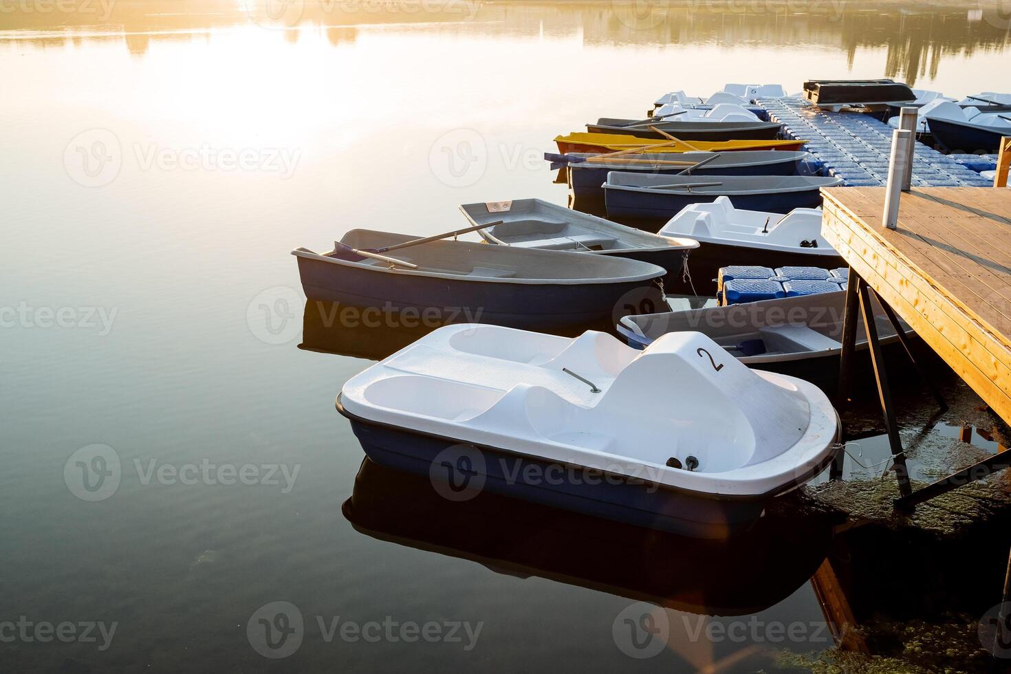 calma agua barco muelle, Mañana amanecer destello de el sol, blanco catamarán para río camina, barco alquiler en el parque, ciudad estanque. foto