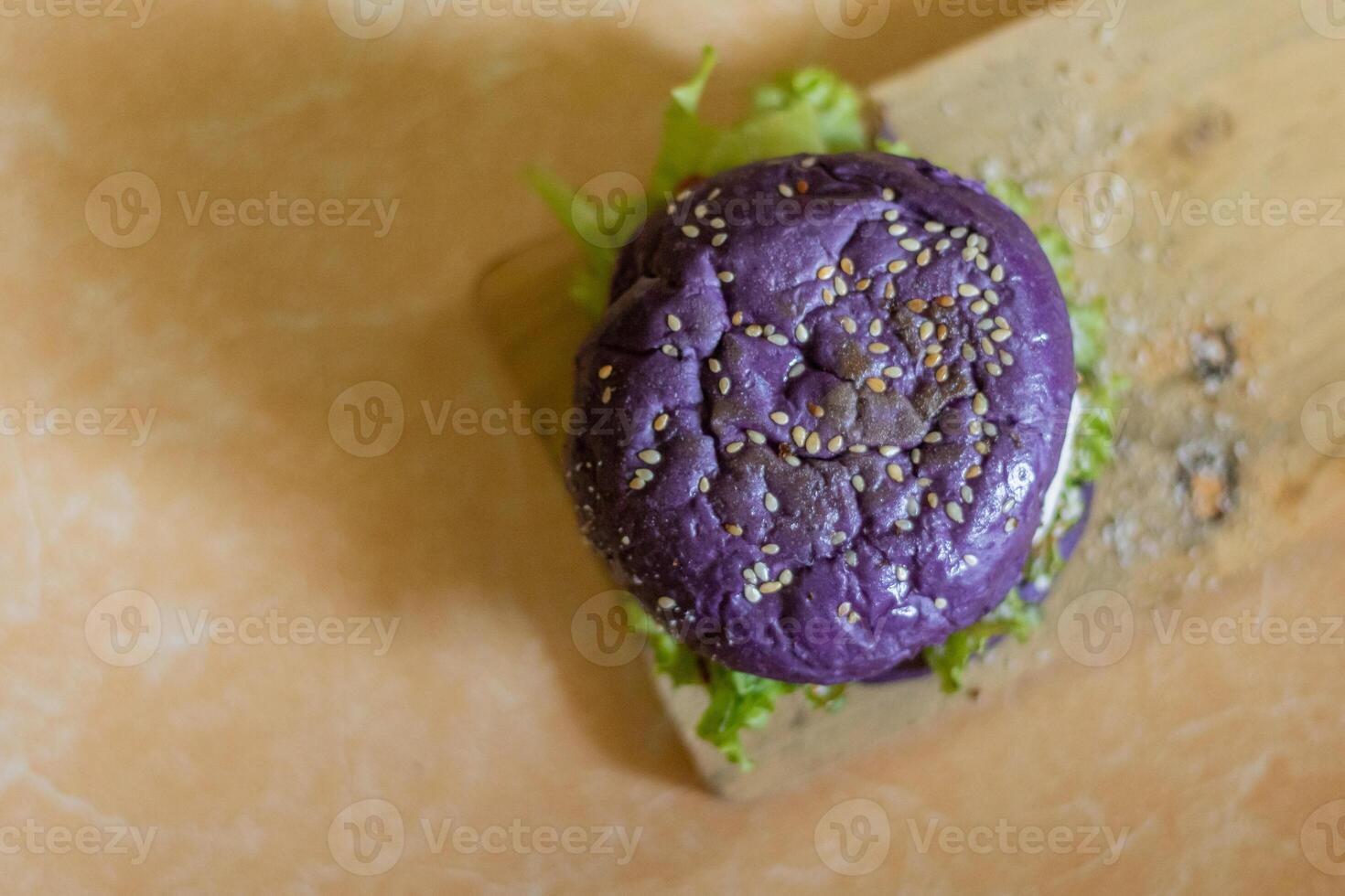 close up photo of a home-made purple burger placed on a ceramic table
