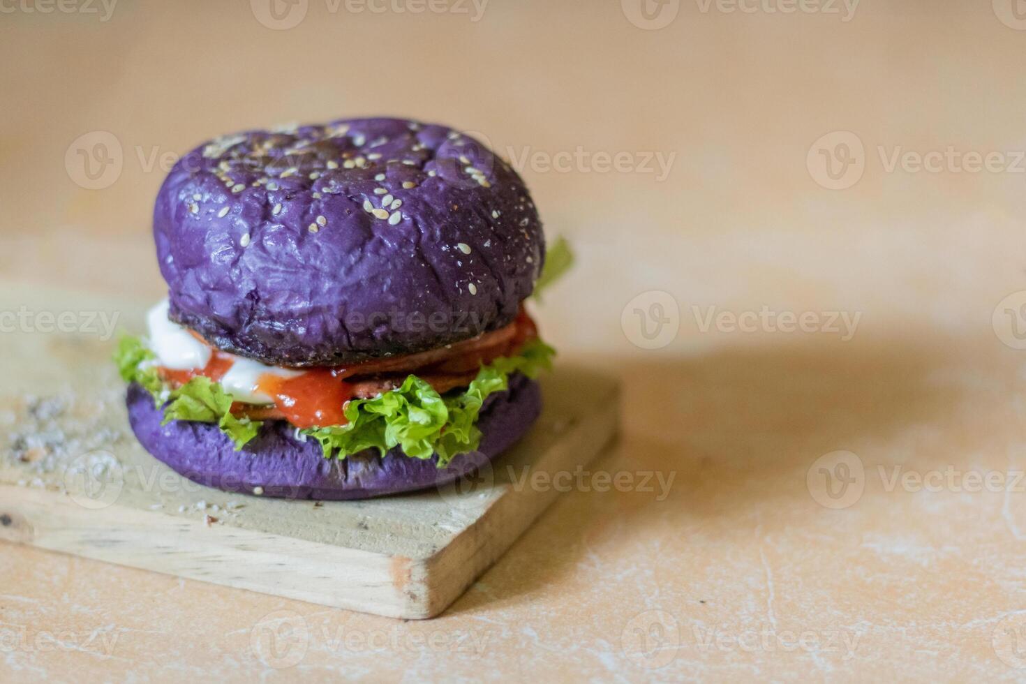 close up photo of a home-made purple burger placed on a ceramic table
