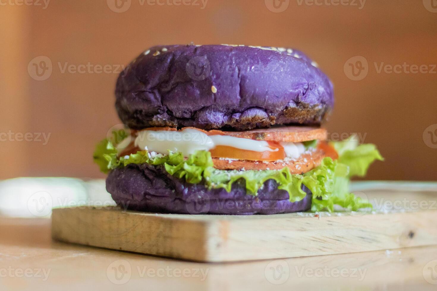 close up photo of a home-made purple burger placed on a ceramic table