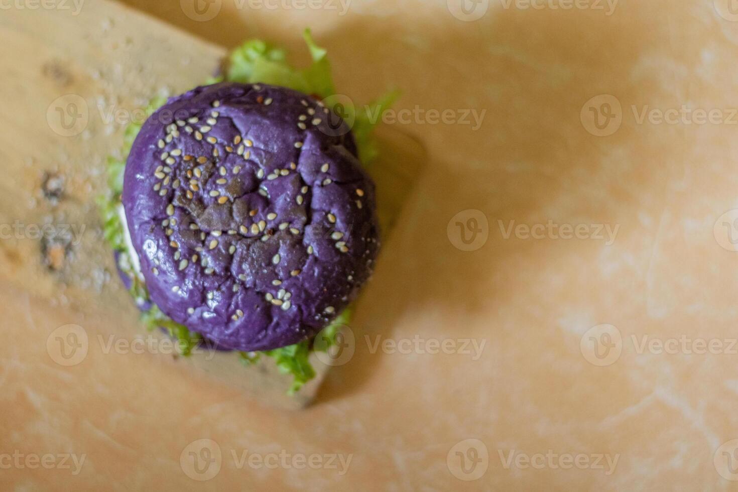 close up photo of a home-made purple burger placed on a ceramic table