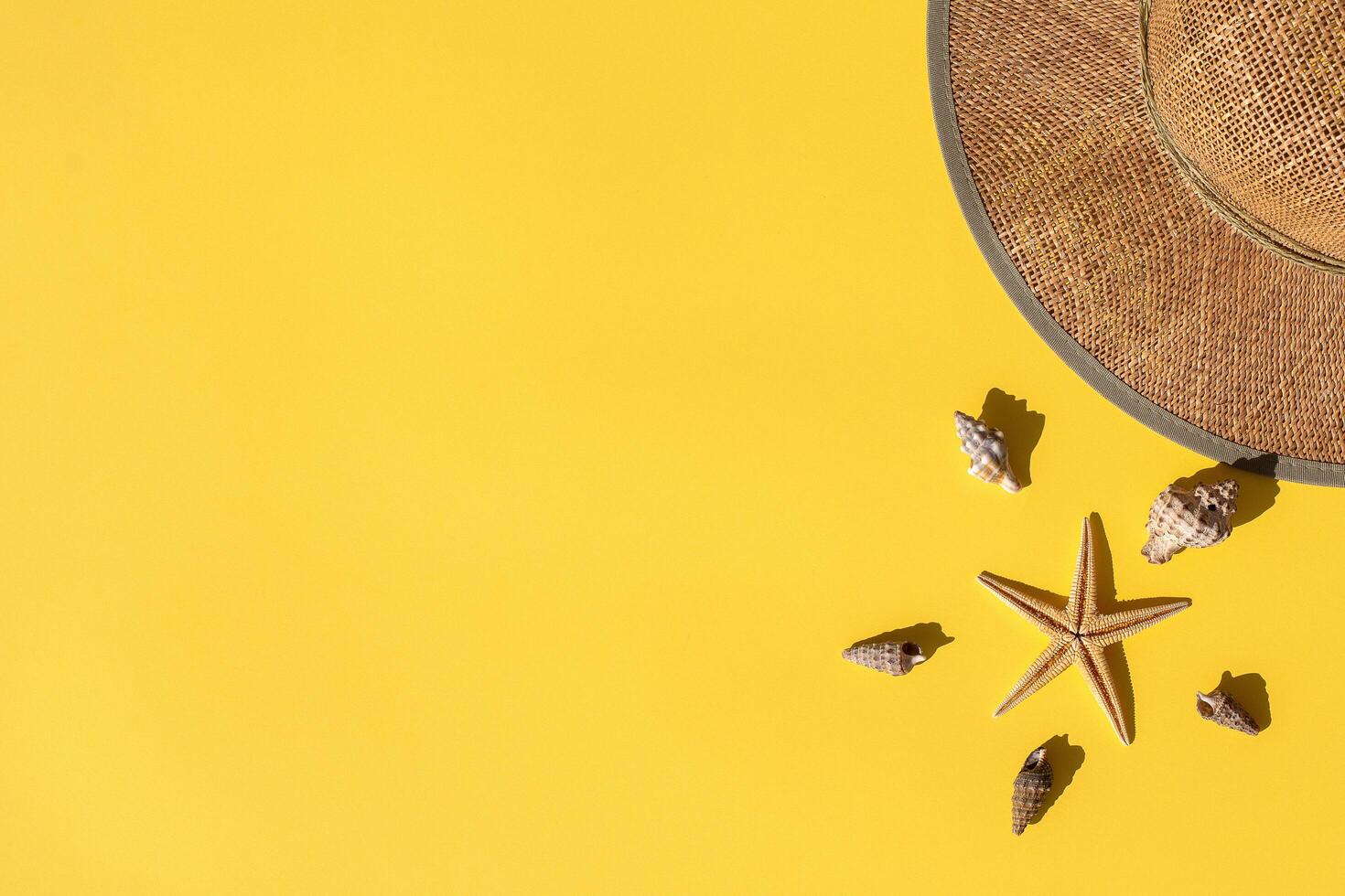 Summer composition. Straw hat, sea shells and starfish on yellow background. Summer concept. Flat lay banner, top view, copy space. Marina style. photo