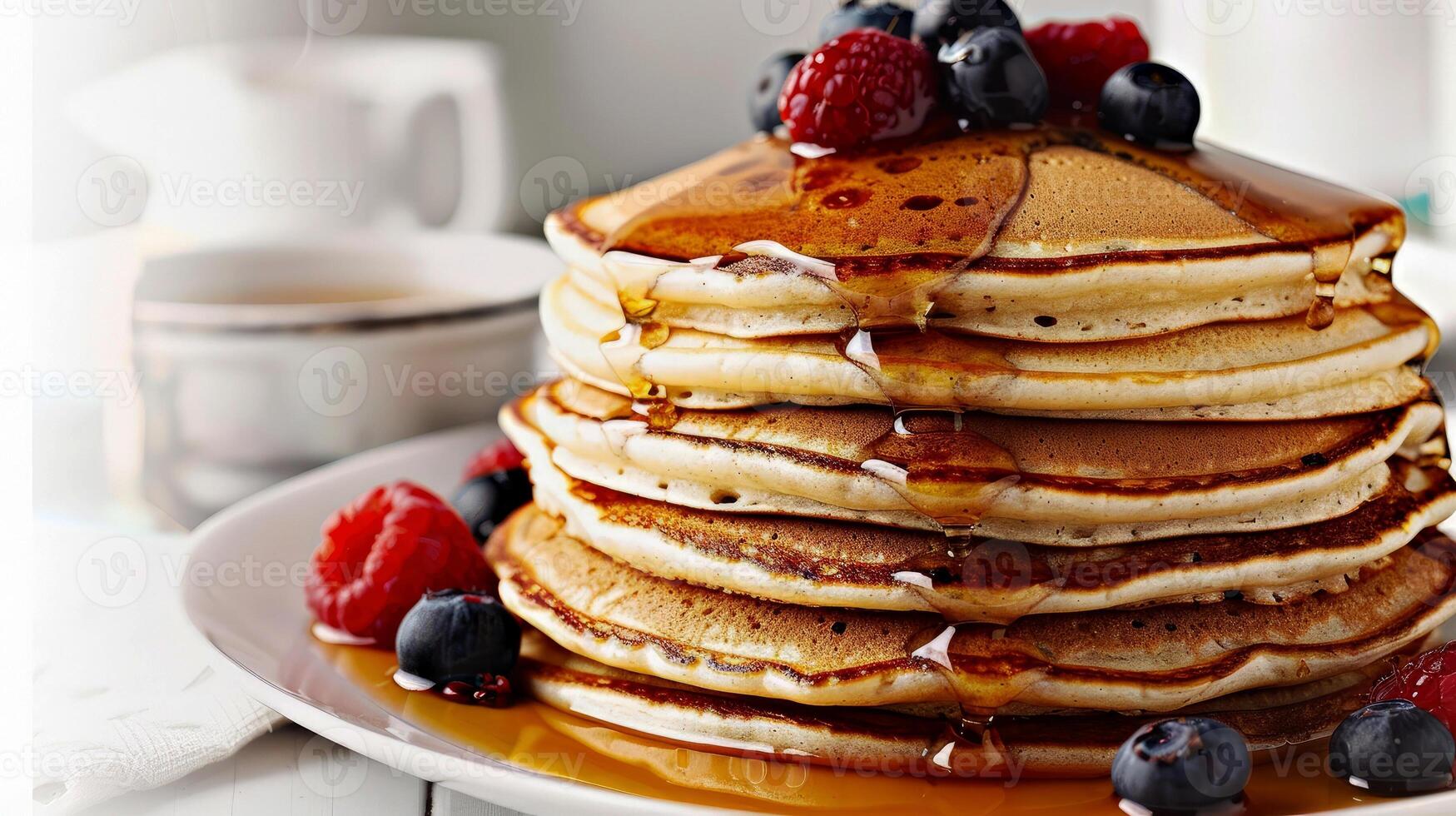 Delicious stack of pancakes topped with syrup and fresh raspberries, blueberries, served on a white plate against a clean white table, perfect for a breakfast concept photo