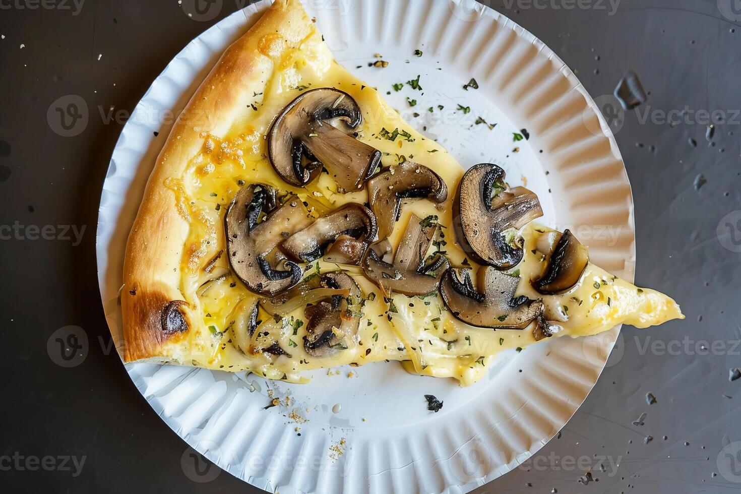 Top view of a slice of pizza with mushrooms on a paper plate. . photo