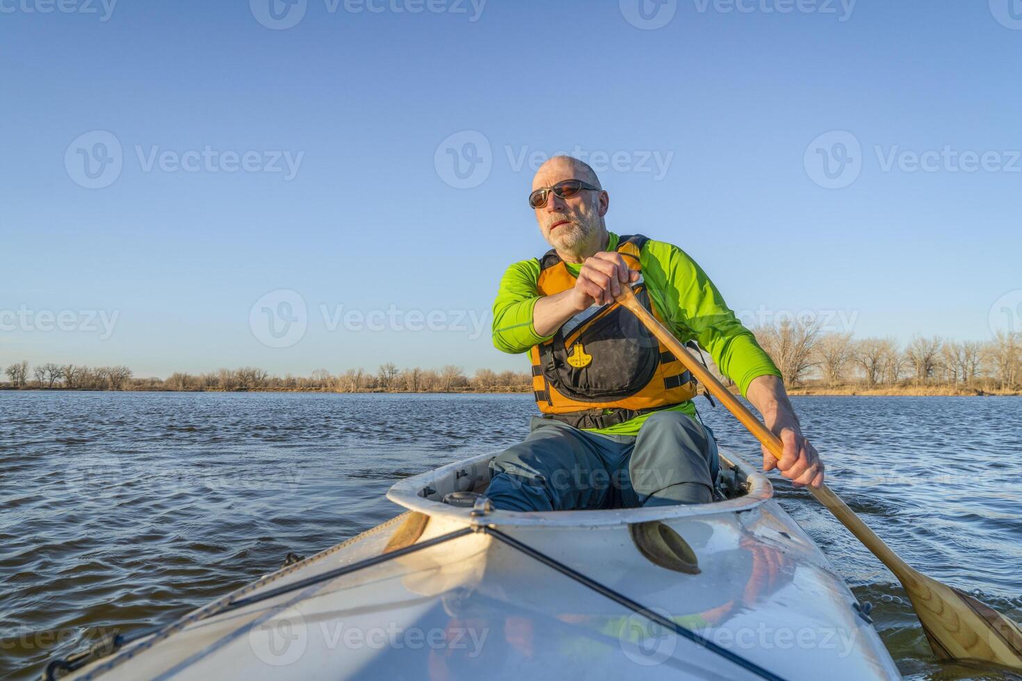 senior male is paddling expedition canoe photo