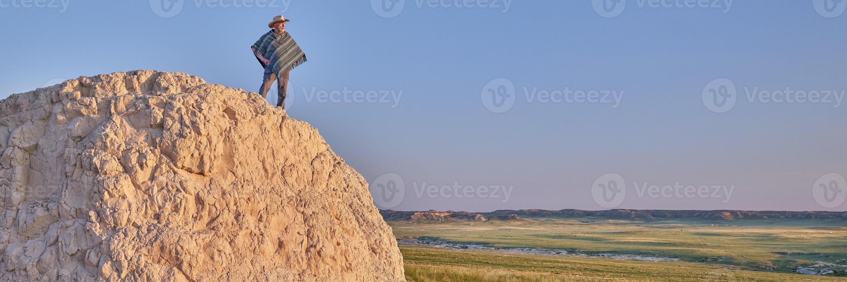 Man in a Mexican poncho and cowboy hat at prairie photo