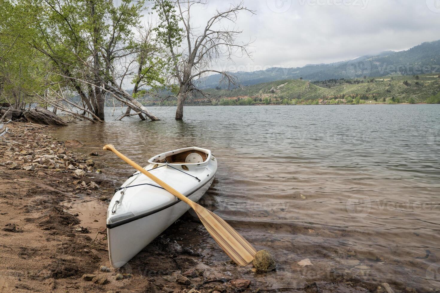 decked expedition canoe with a wooden paddle photo