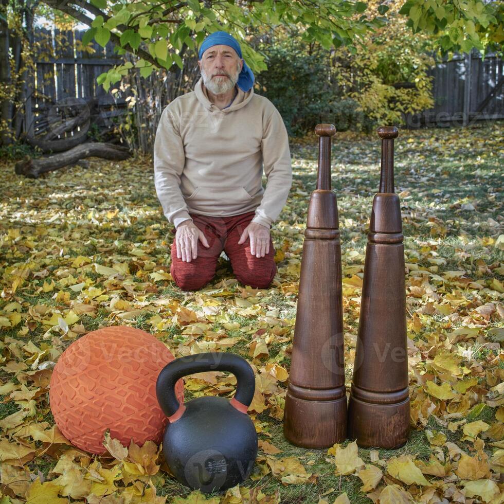 heavy iron kettlebell, slam ball and wooden Persian clubs photo
