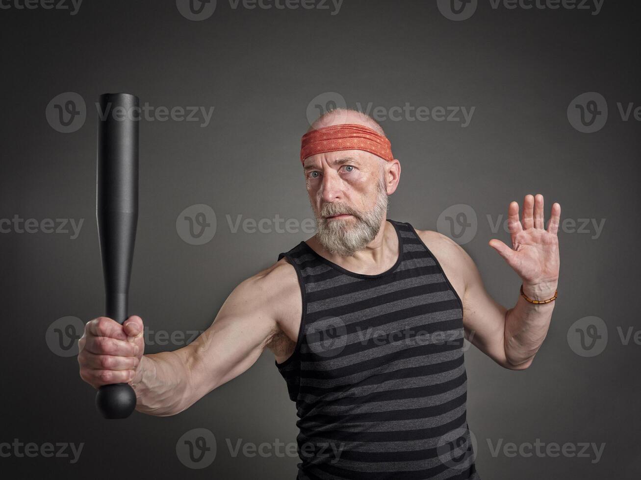 senior man is exercising with a steel club photo