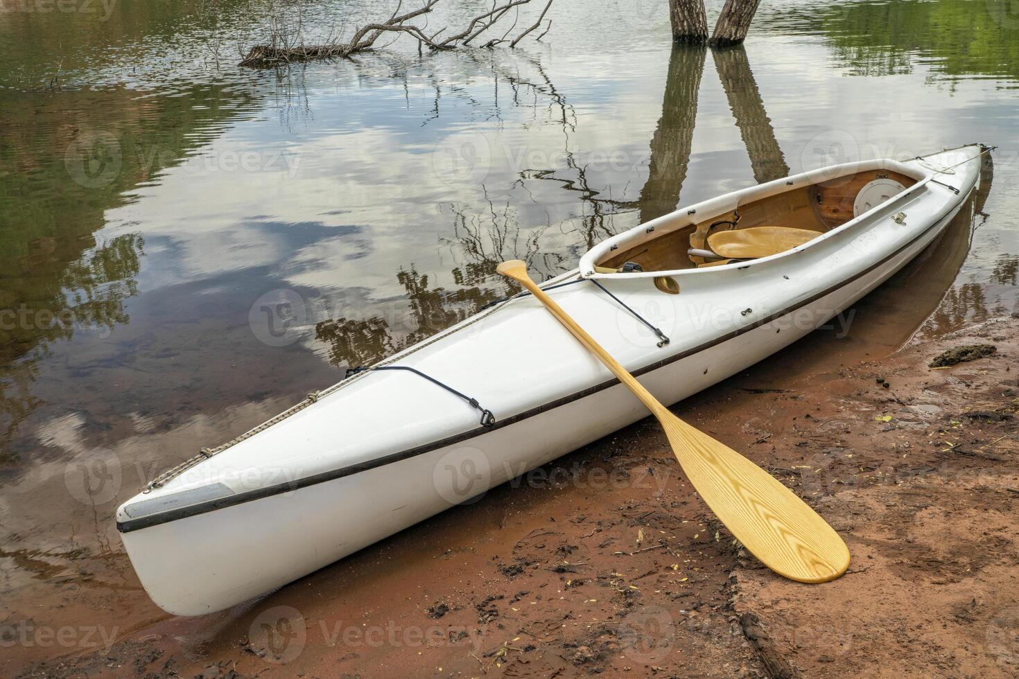 decked expedition canoe with a wooden paddle photo