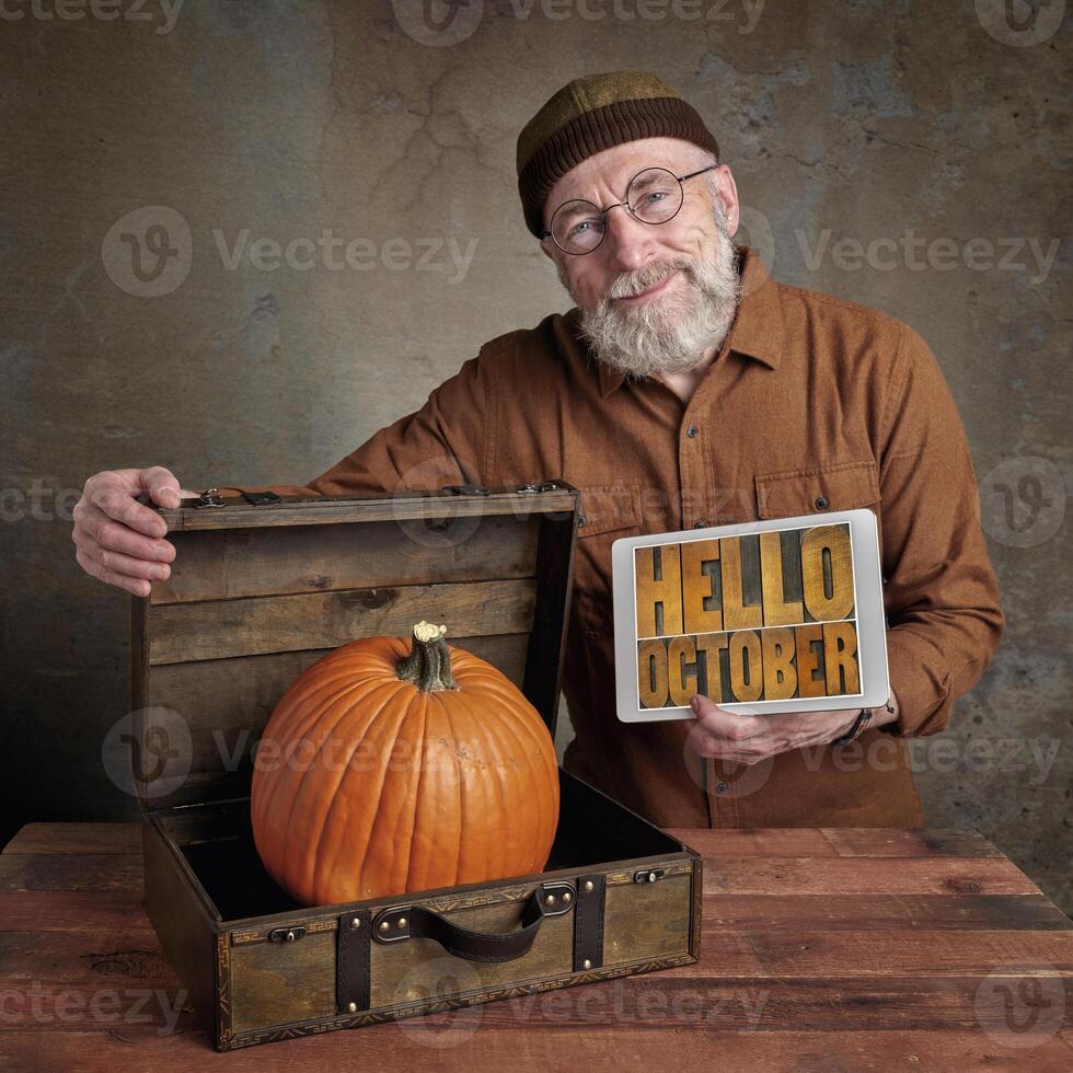 Hello October - smiling senior man with pumpkin photo