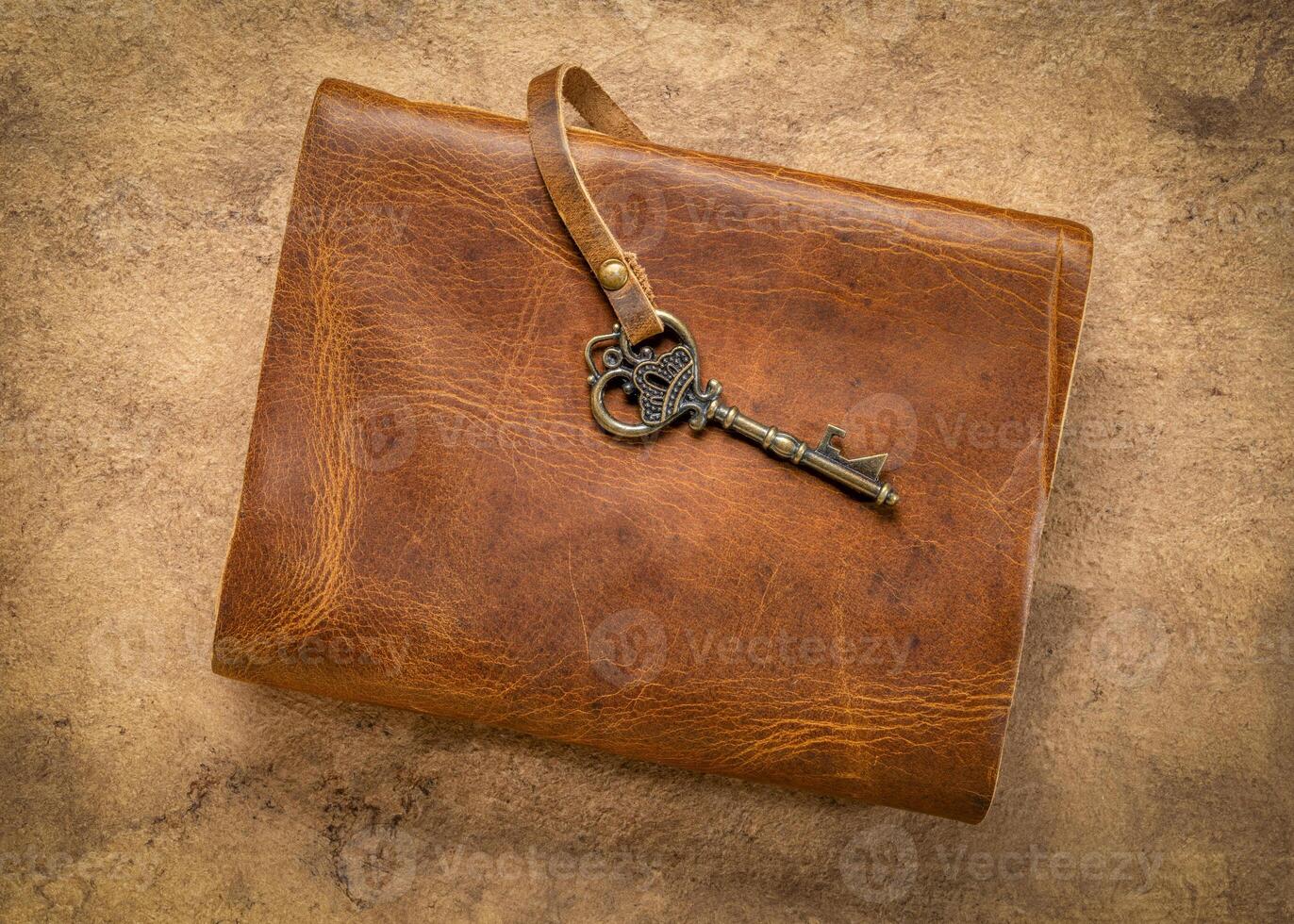 retro leather-bound journal with a decorative key on a handmade bark paper, journaling concept photo