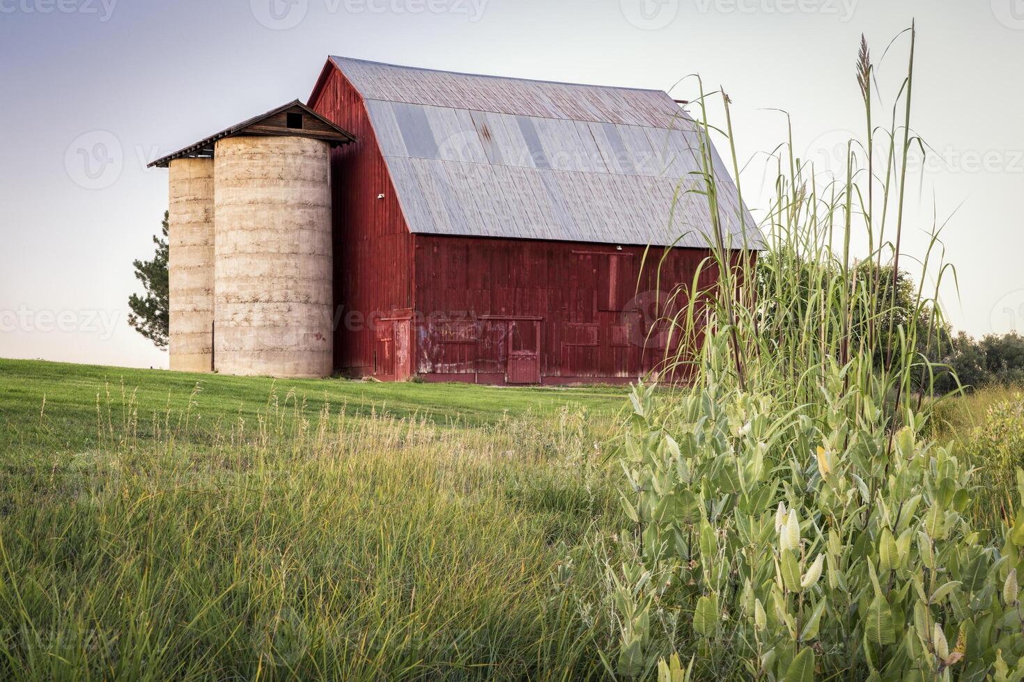 old red barn with twin silo and irrigation ditch photo