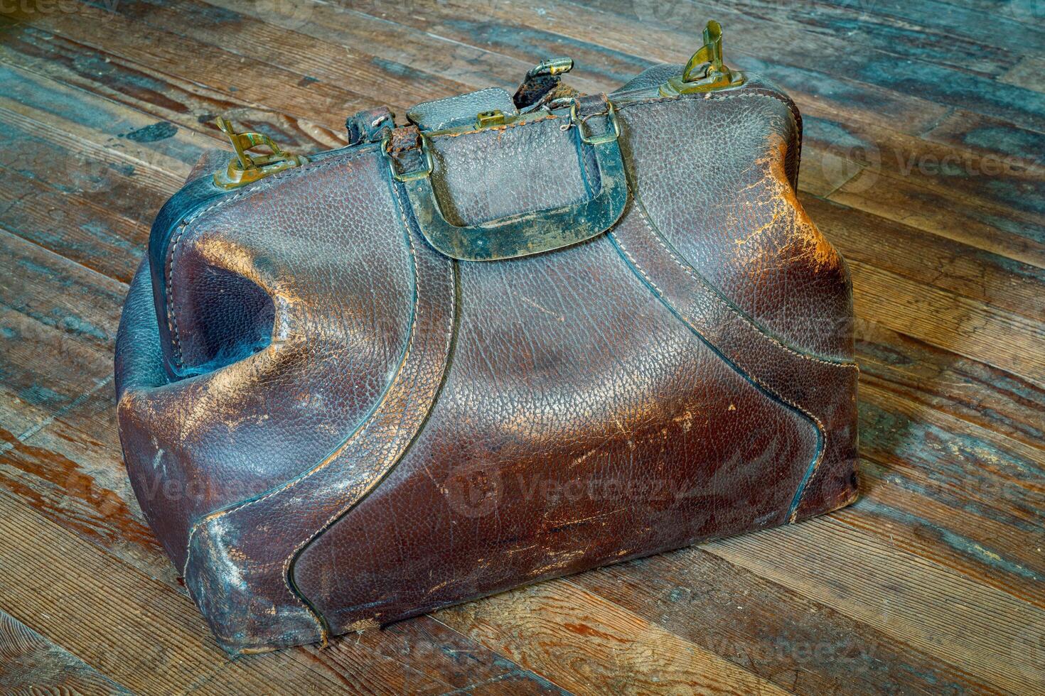 old vintage leather medicine bag on a dusty wooden floor photo