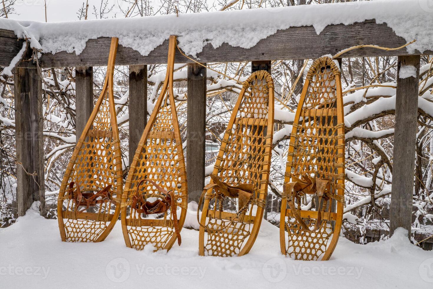 clásico de madera raquetas de nieve, hurón y oso pata, en un patio interior con nieve que cae foto