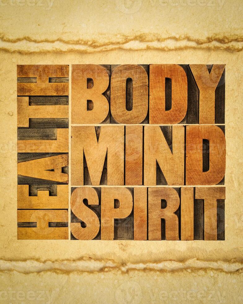 health, body, mind and spirit word abstract - a collage of text in vintage wood letterpress printing blocks on art paper, wellbeing and personal development concept photo