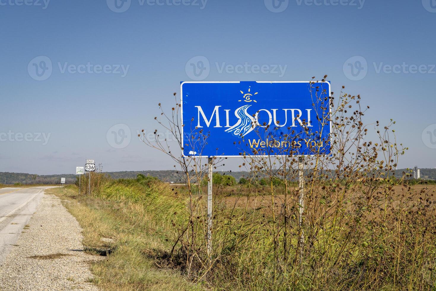 Missouri Welcomes You - a roadside sign at a state border with Nebraska, fall scenery with dry sunflowers photo