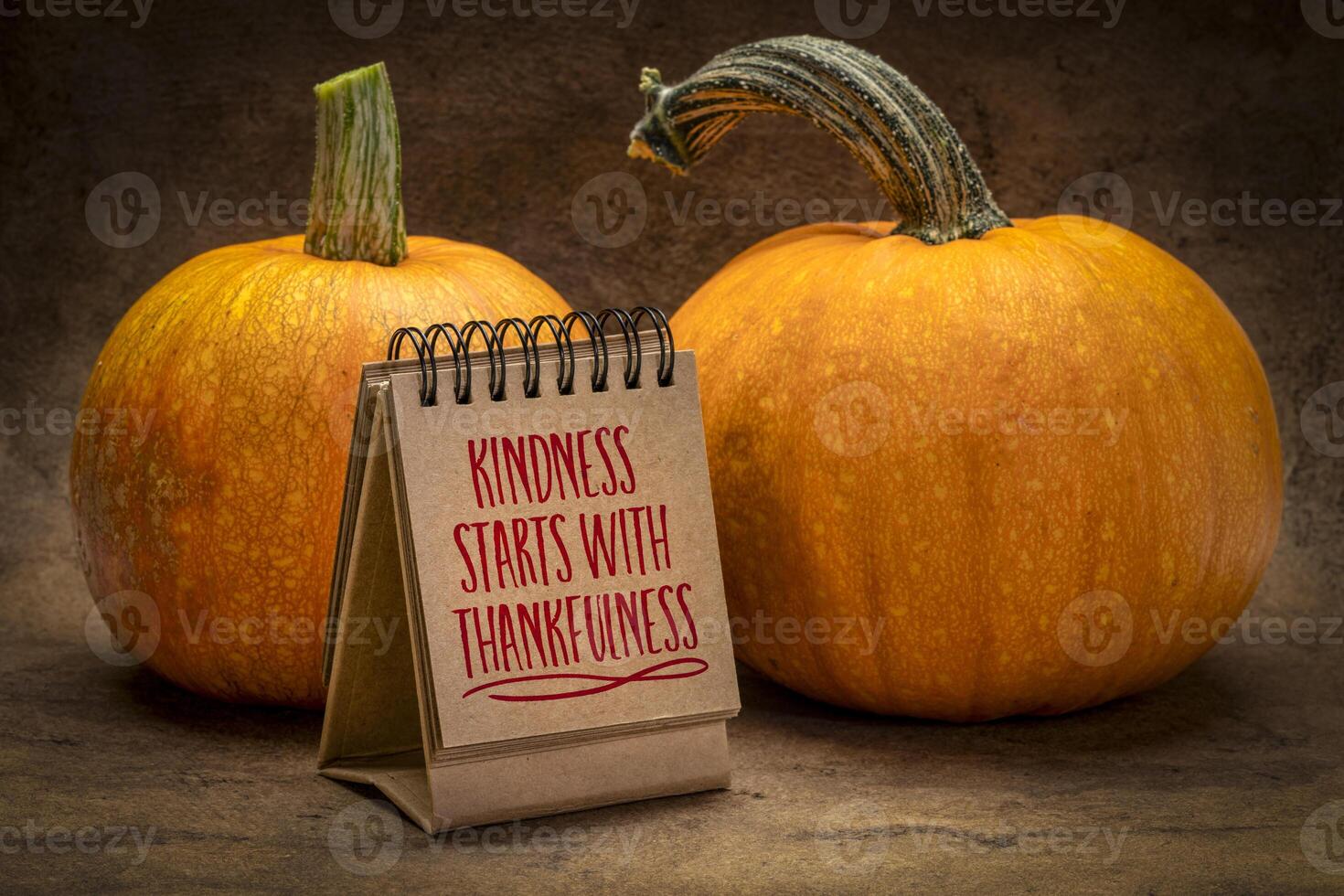 Kindness start with thankfulness - handwriting in a desktop calendar with pumpkins, November and Thanksgiving season concept photo