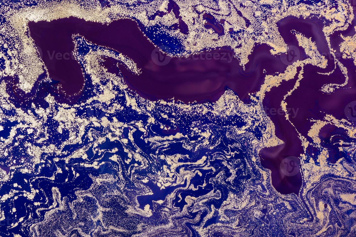 Acrylic Fluid Art. Purple Waves Pattern with Gold sparkles on blue background. Abstract marble background or texture photo