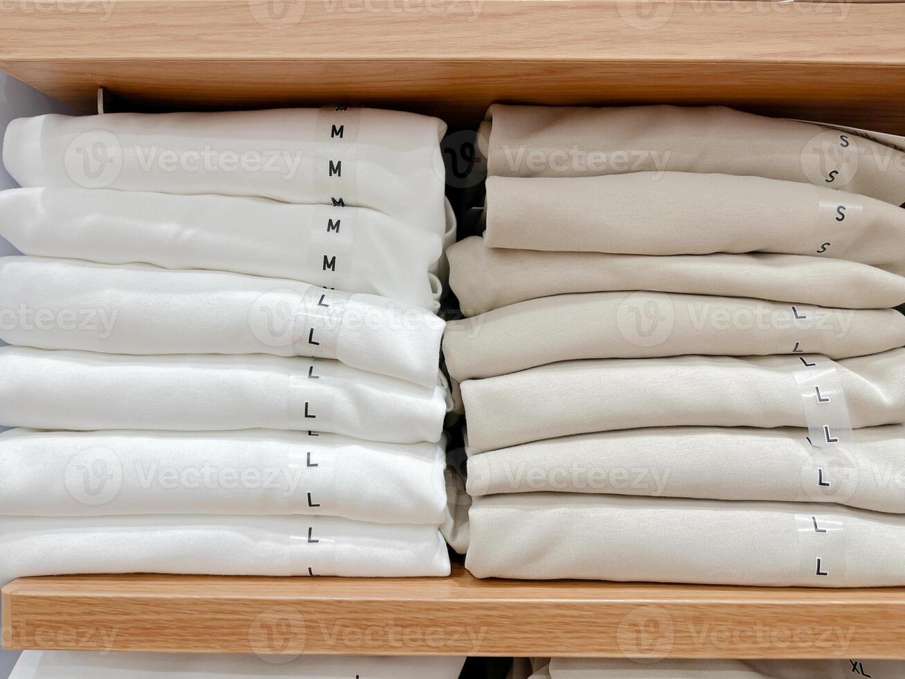 doblada camisas en un estante en un almacenar. foto