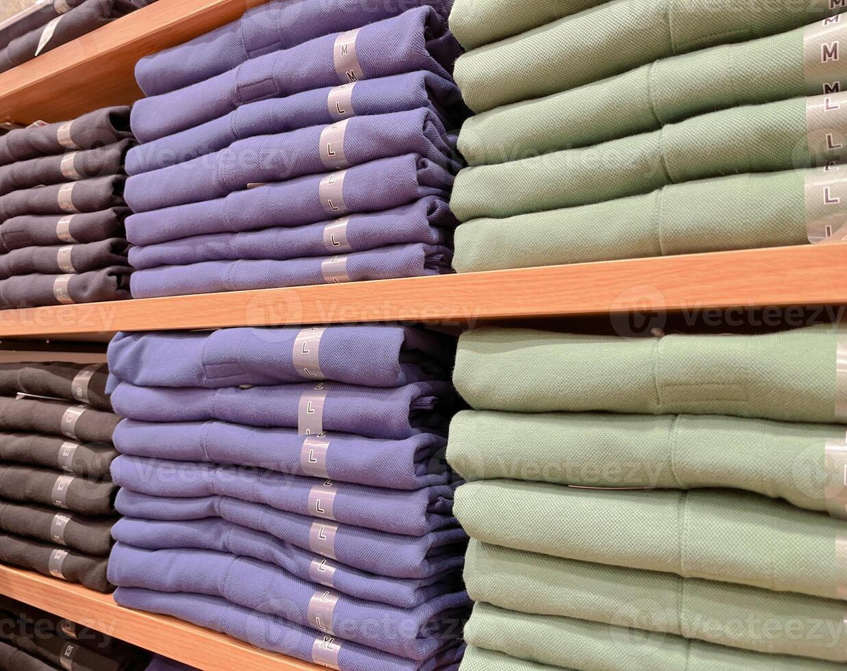 Folded shirts on a shelf in a store. photo