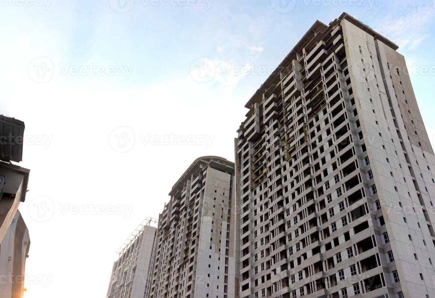 alto subir Departamento edificio debajo construcción con azul cielo antecedentes en el tarde. después algunos ediciones foto