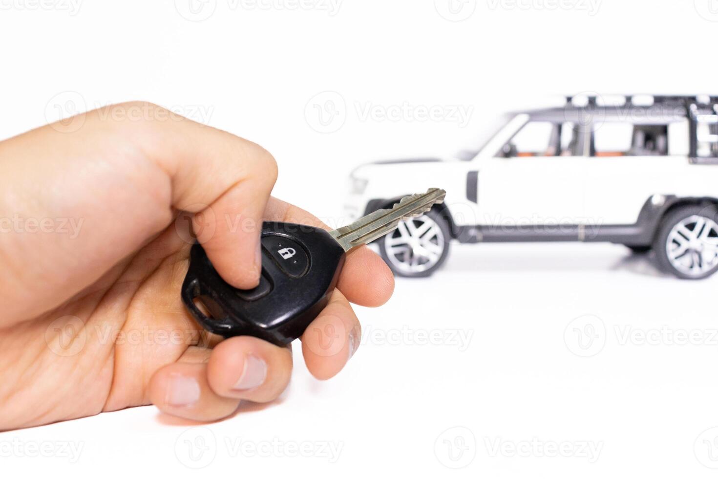 coche llave en mano con juguete coche en el antecedentes aislado en blanco. coche cosas concepto. después algunos ediciones foto