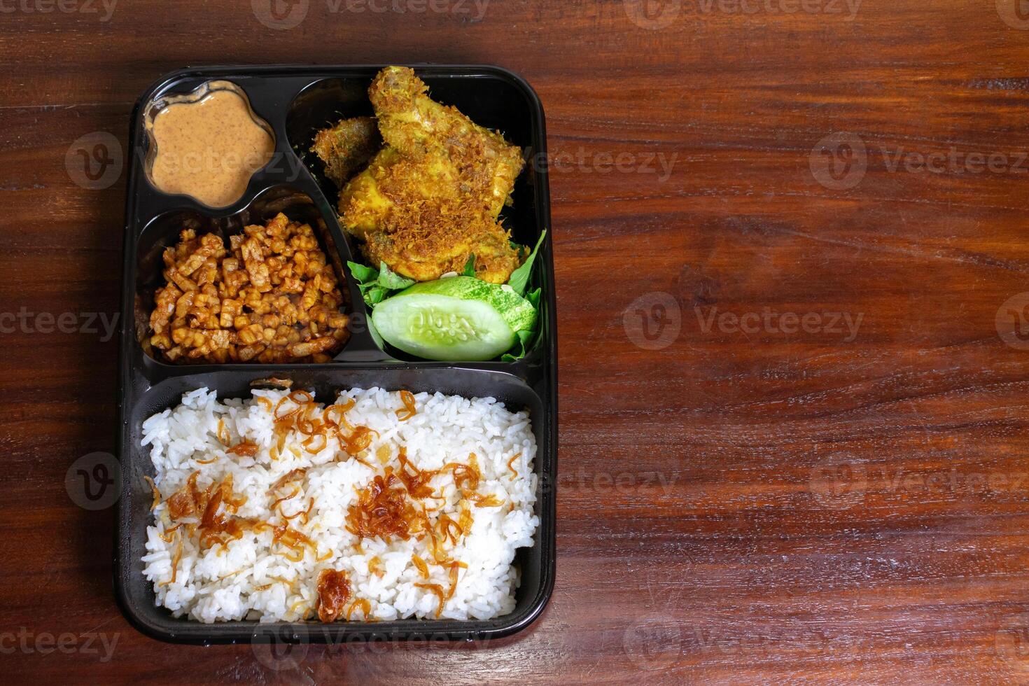 indonesio comida caja llamado uduk metido en el de madera mesa. después algunos ediciones foto