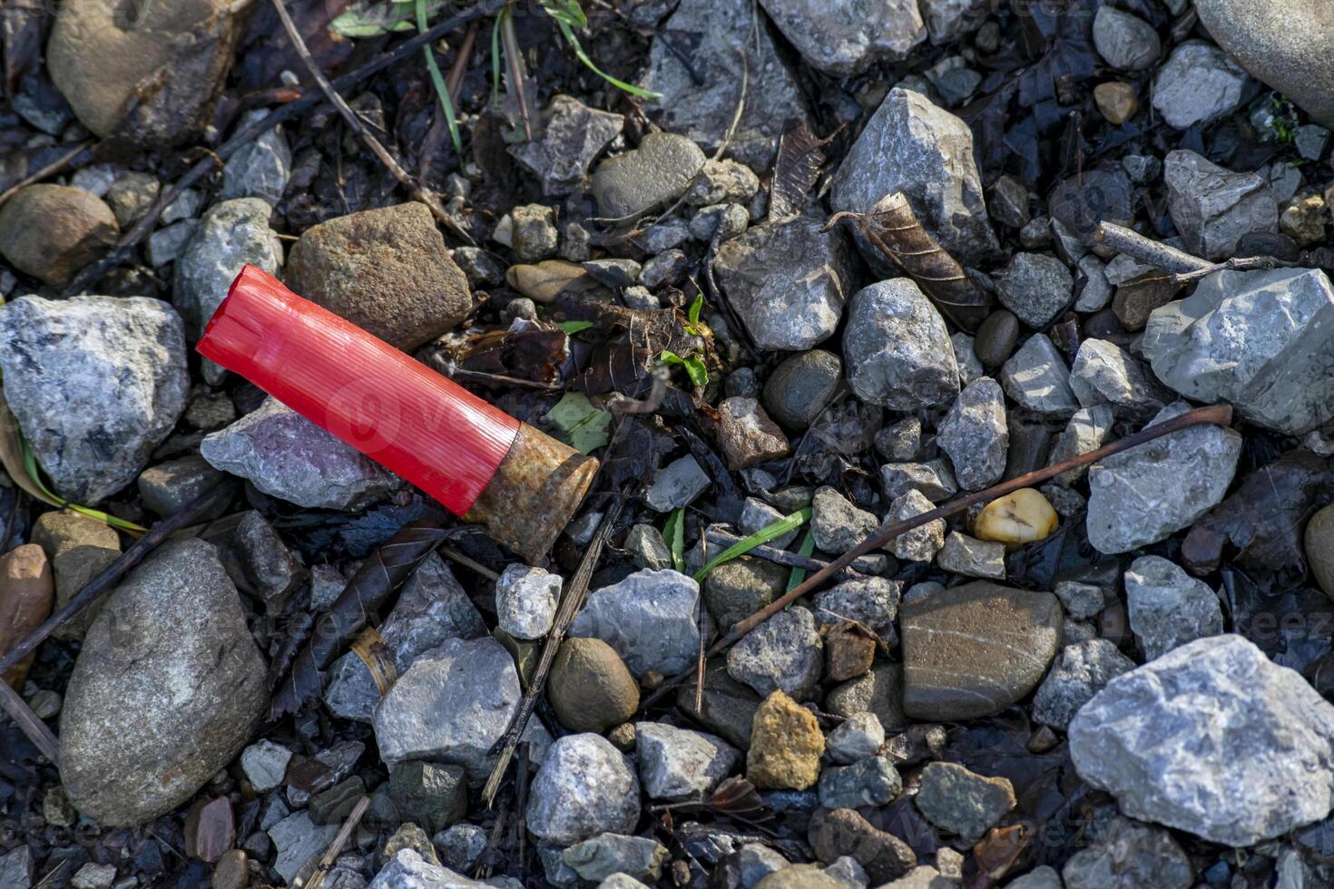 A spent cartridge case from a hunting cartridge lies in the middle of a mountain road. photo
