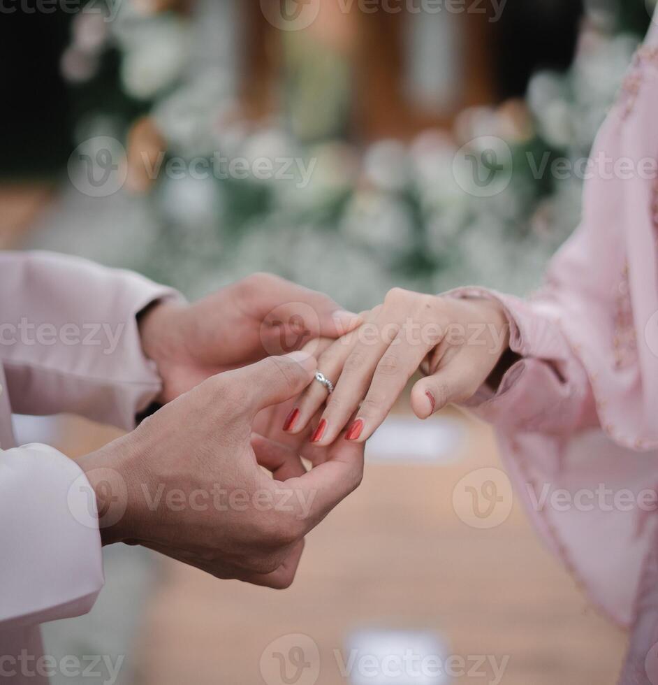 Close up Groom Put the Wedding Ring on bride photo