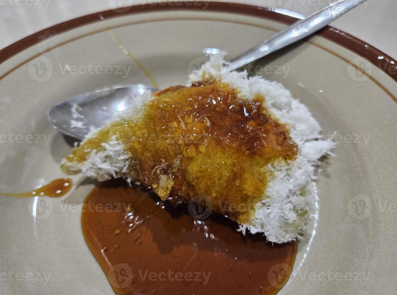 un foto de lupis, un indonesio tradicional dulce pastel hecho de glutinoso arroz, plátano hojas, Coco, y marrón azúcar salsa. lupis es uno de muchos postres desde Indonesia.