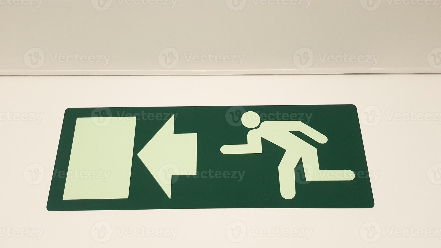 Green emergency exit sign showing the way to escape. Fire exit in the building. emergency sign consept photo