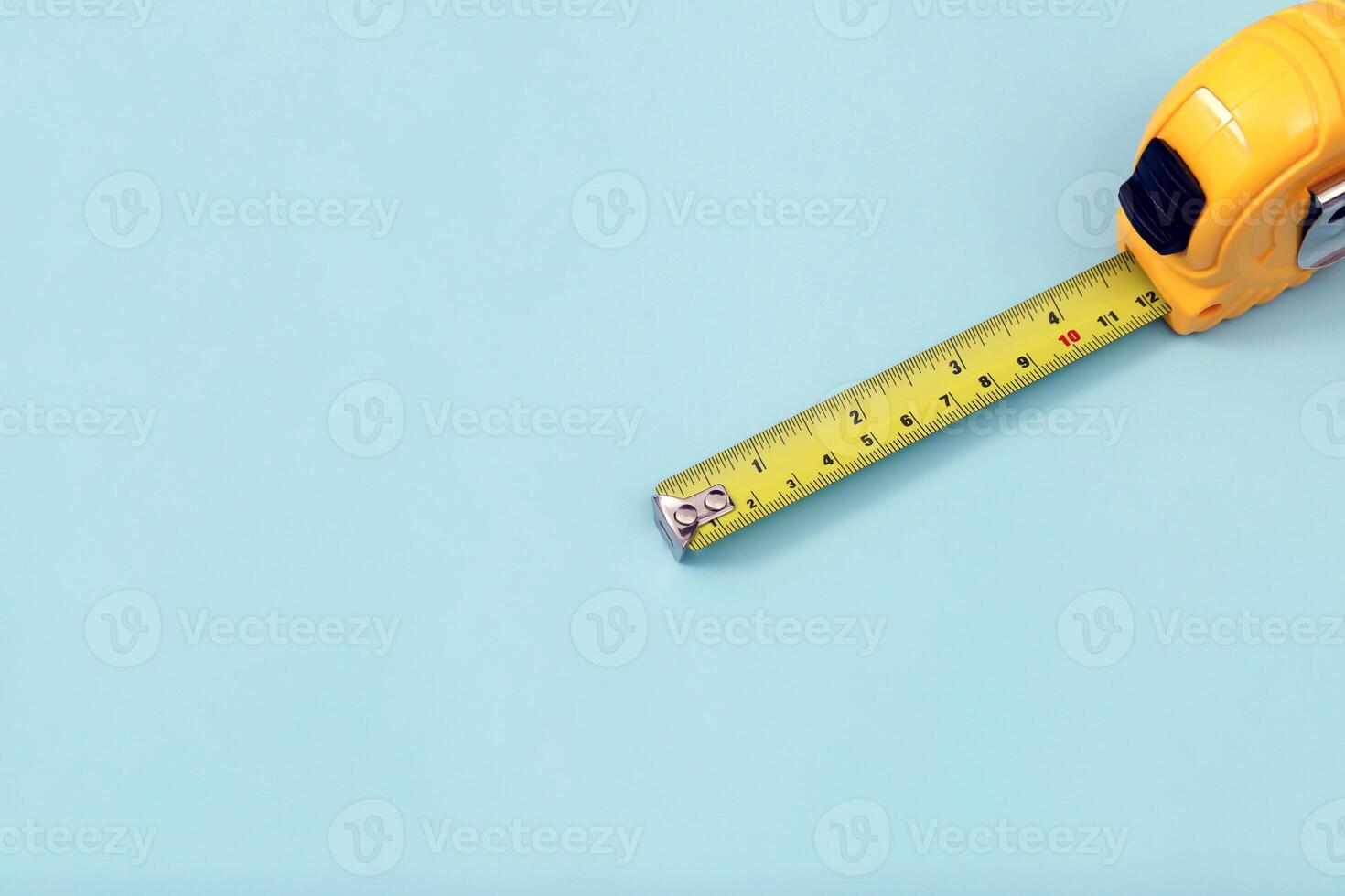 The yellow measuring tape for the mason is placed on a blue background. Soft focus. photo