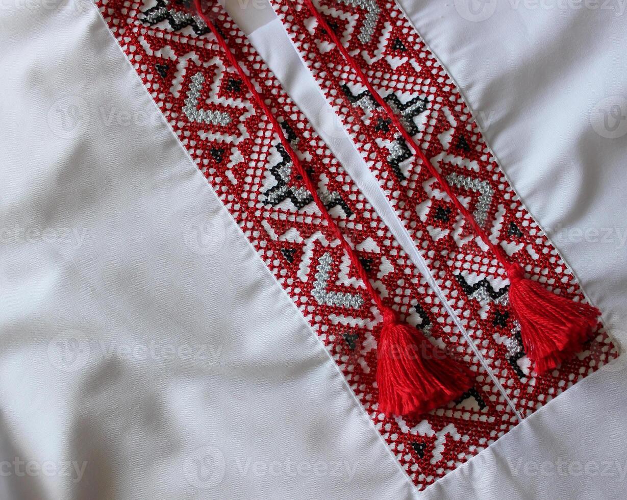 Closeup photo of fragment of Ukrainian traditional vyshyvanka shirt embroidered with red and black threads