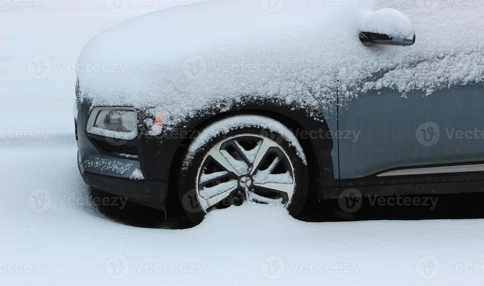 Front Part Of Vehicle Littered With A Large Layer Of Snow On A Street photo