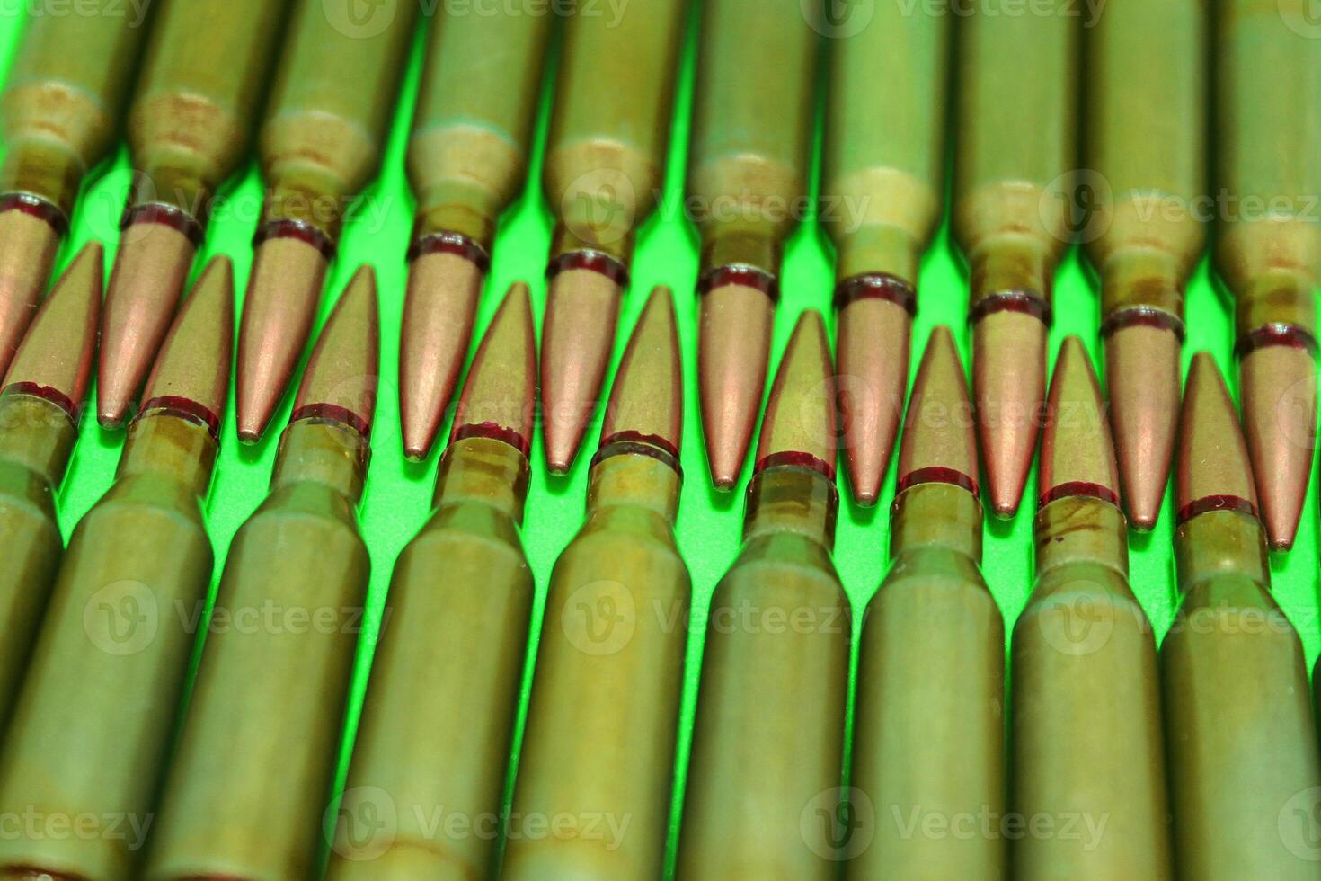 Rows Of Assault Rifle Bullets On A Green Surface Isolated Stock Photo