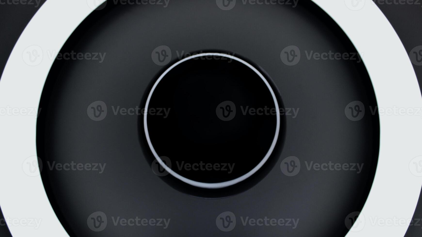 A black shiny sphere reflects glares from a ring lamp concept photo for space backgrounds
