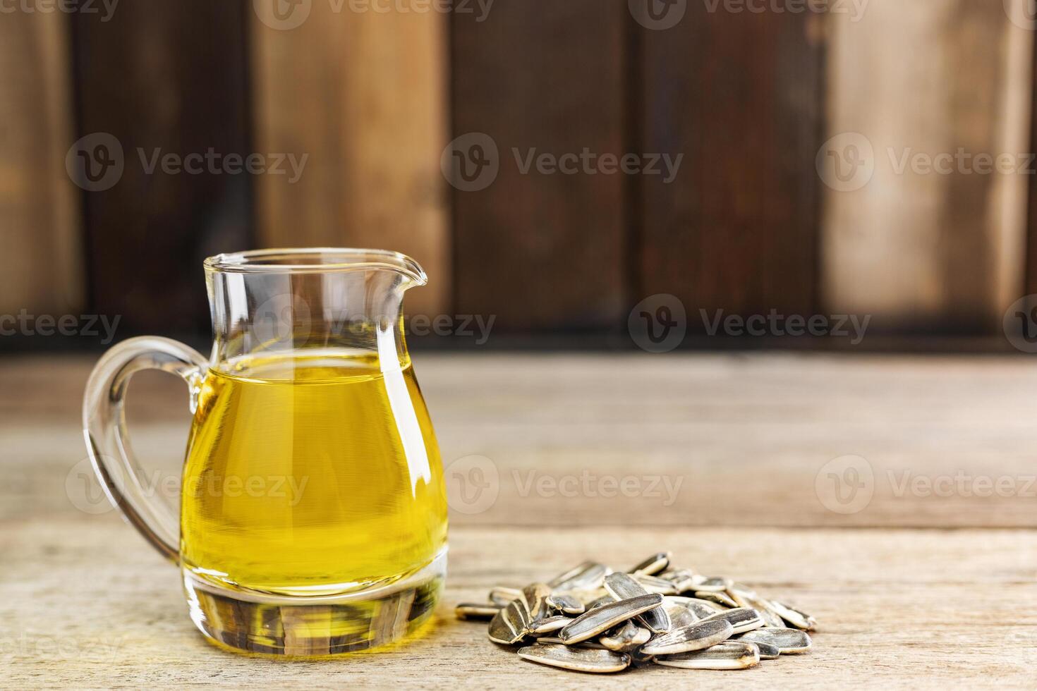 Sunflower oil and sunflower seeds On a traditional rustic wooden floor Concept of organic food and environment Healthy food and fat photo