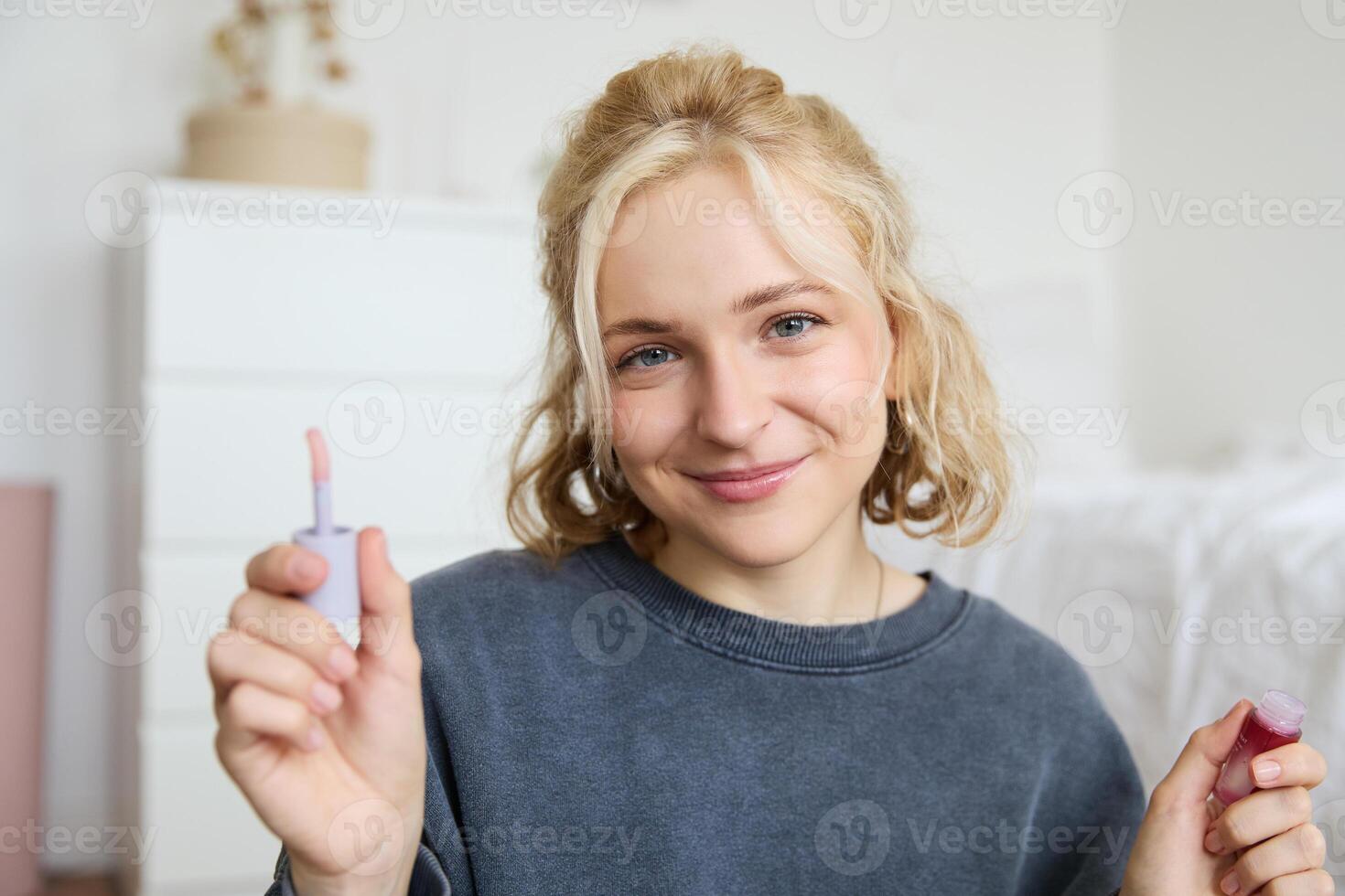 Portrait of young beautiful woman, content maker creating a new vlog, beauty , showing lipstick, recommending makeup, records a tutorial photo