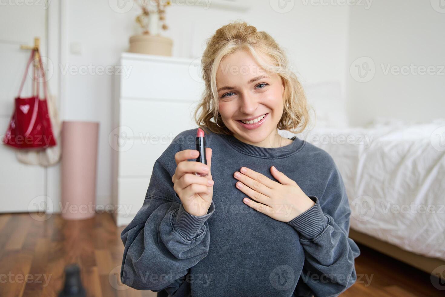 Portrait of young beautiful woman, content maker creating a new vlog, beauty , showing lipstick, recommending makeup, records a tutorial photo