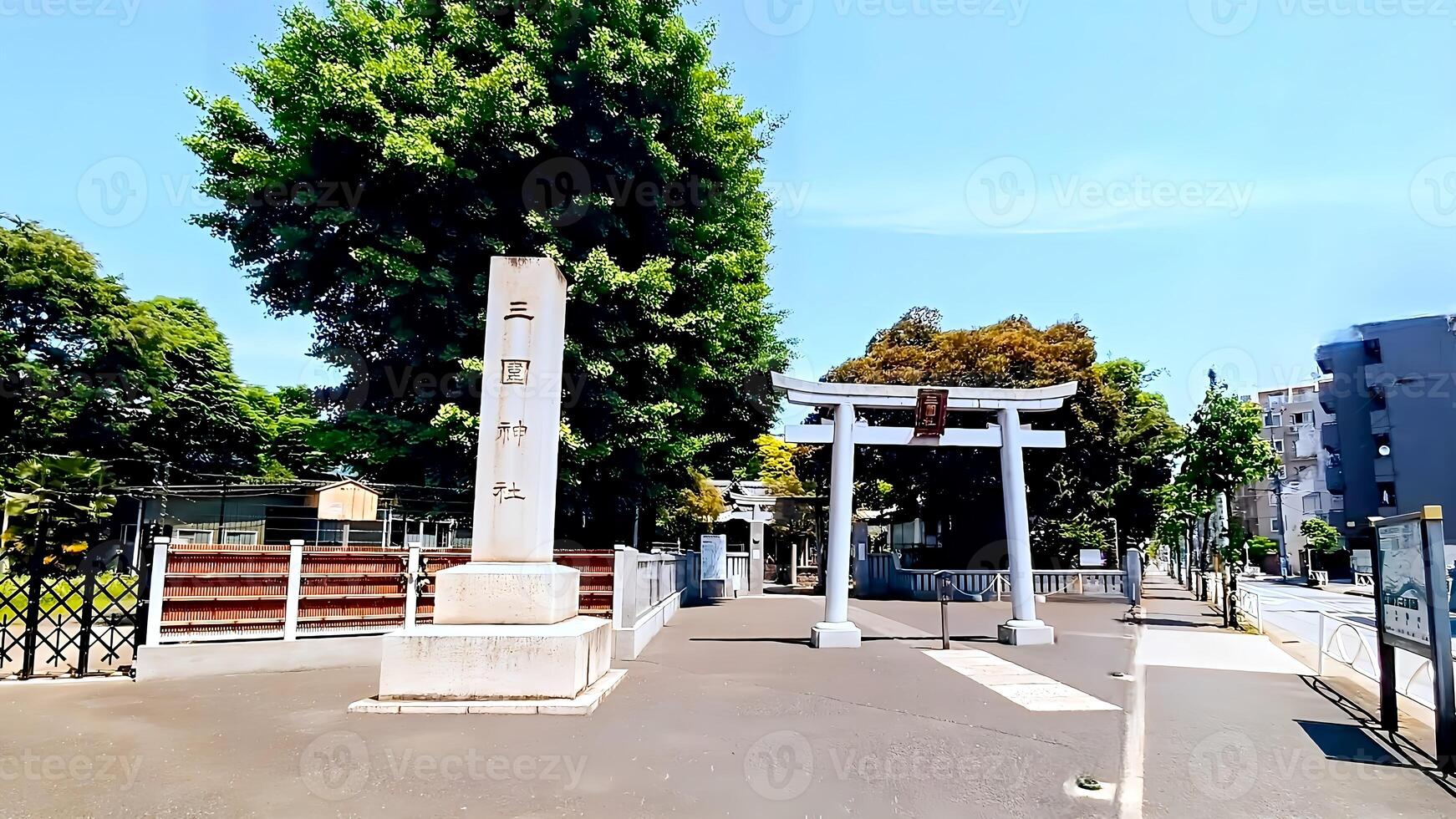 Mimeguri Shrine, a torii gate in the fresh greenery facing the street.Mimeguri Shrine is a shrine located in Mukojima, Sumida Ward, Tokyo, Japan. photo