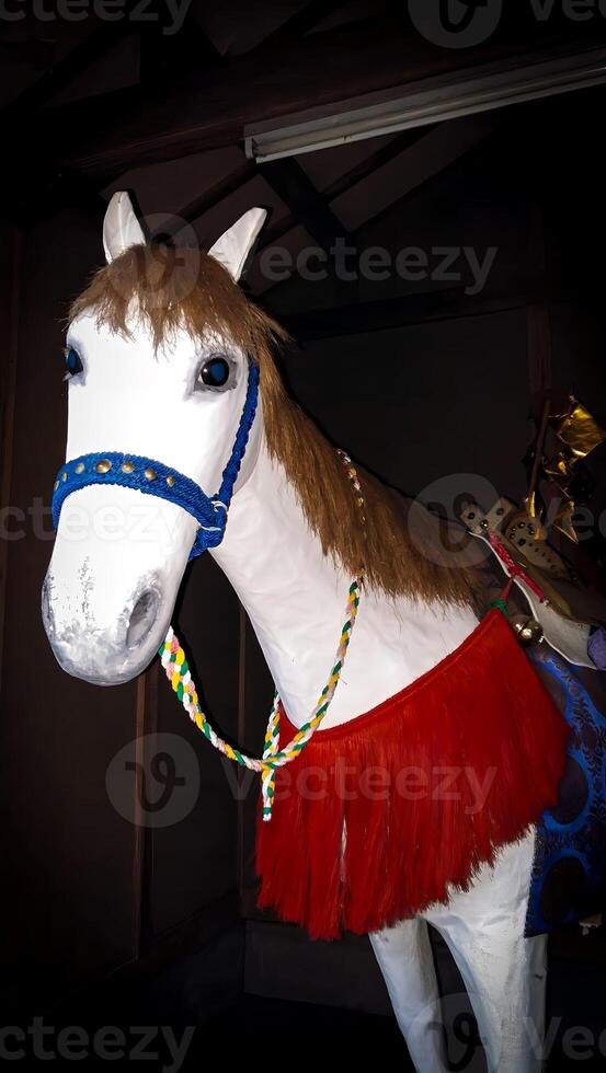 A white horse ornament dedicated to a shrine. A horse considered sacred as a horse ridden by gods. A horse that is dedicated to a Japanese shrine or appears during festivals. photo