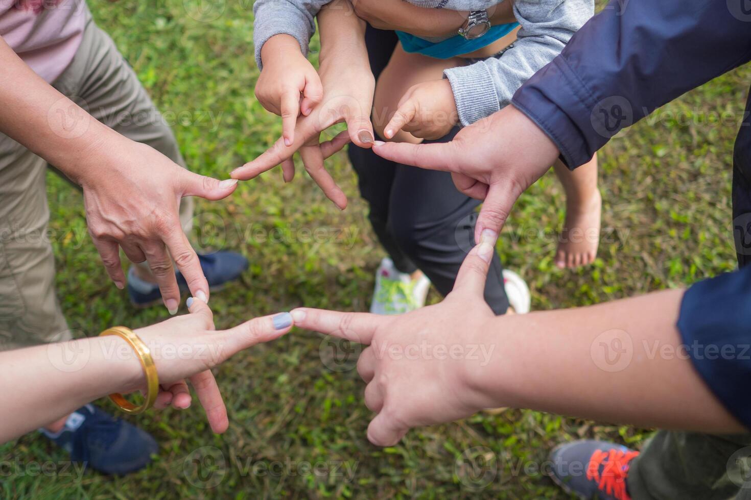 Close-up top view of hands women and kid, use fingers touch each other in a circle. Showing unity and teamwork photo