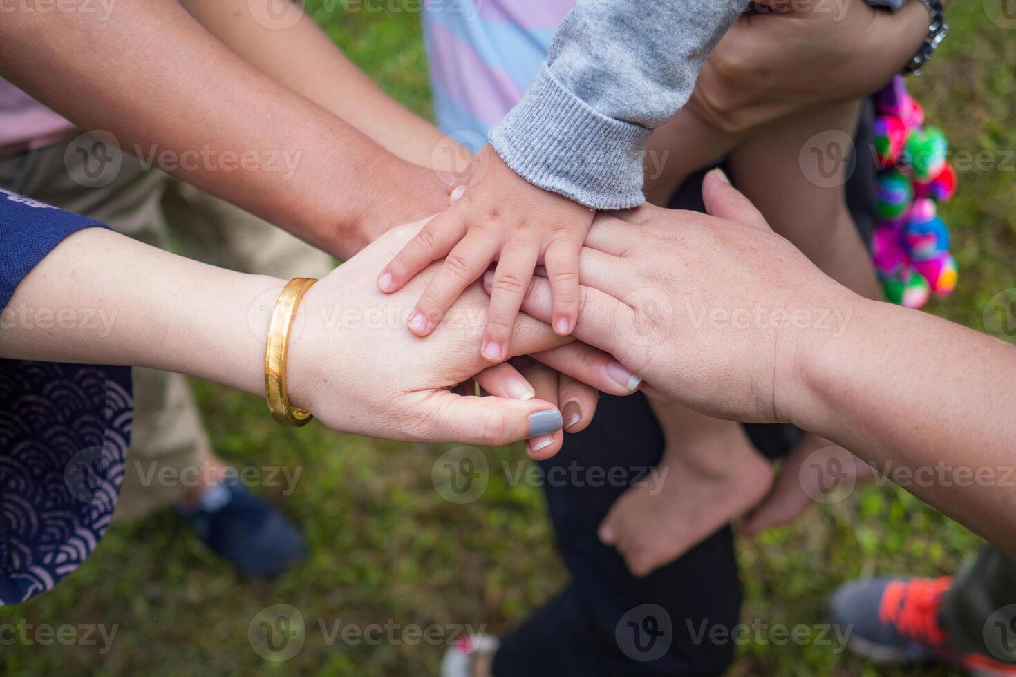 Close-up top view of hands women and kid putting theirs together. Family with a stack of hands showing unity and teamwork photo